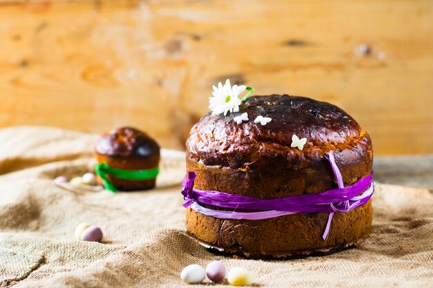 Ostern süßes Brot orthodoxer kulich, paska, Weidenzweige. Bunte Eier Ostern auf hölzernem Hintergrund.