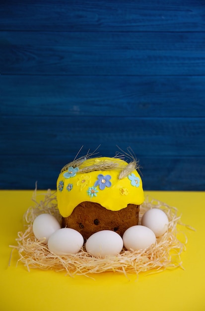 Ostern. Traditioneller ukrainischer Osterkuchen mit Eiern auf blauem und gelbem Hintergrund.