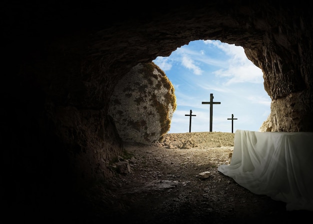Ostern und Karfreitag Konzept leeres Grab mit Kreuz auf dem Berg auf einem blauen Himmel Kreative Idee Ostern Religion und Christentum Offene leere Höhle Freier Kopierraum für das Design