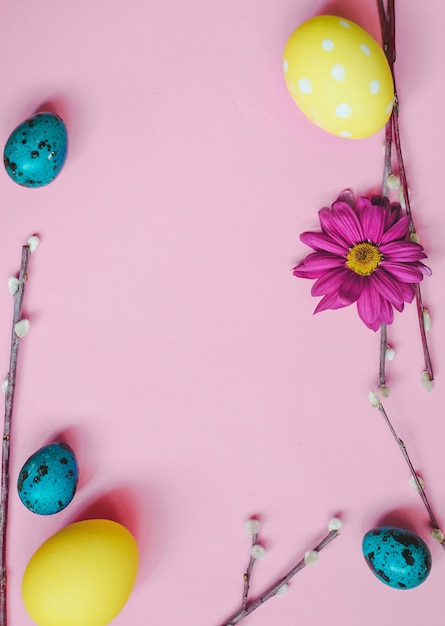 Ostern-Wachteleier, Frühlingsblumen und Weide auf rosa Hintergrund