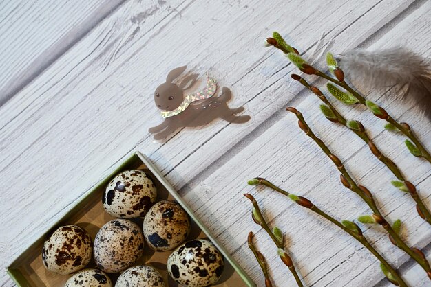 ostern weiße hähnchen- und wachteleier grauer kraftpapierhintergrund heller hintergrund weidenzweige ostern