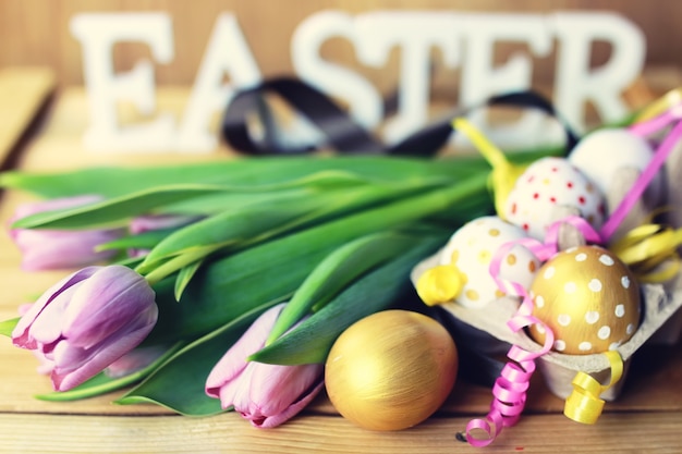 Ostern-Zusammensetzungsblume und -eier auf hölzernem Hintergrund