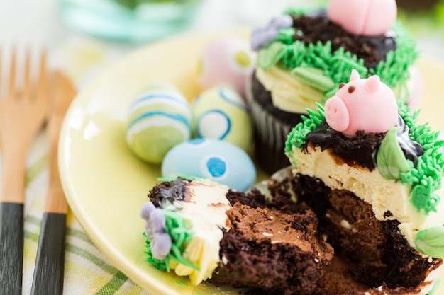 Osterschokoladen-Cupcakes verziert mit Schweinchen und Hasenohren.