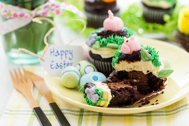 Osterschokoladen-Cupcakes verziert mit Schweinchen und Hasenohren.