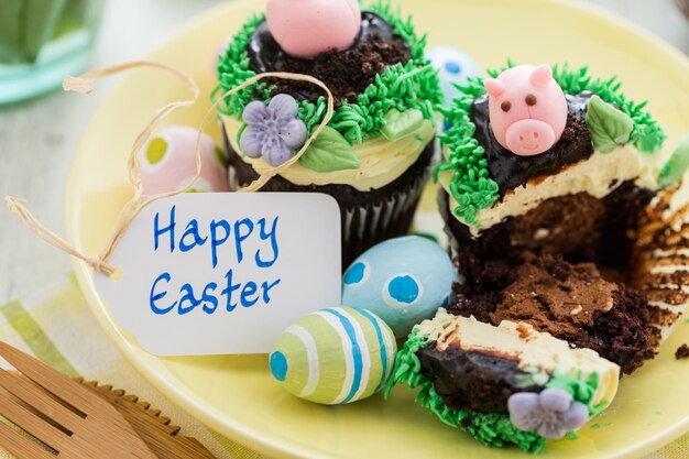 Osterschokoladen-Cupcakes verziert mit Schweinchen und Hasenohren.