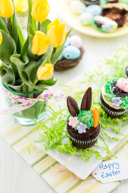 Osterschokoladen-Cupcakes verziert mit Schweinchen und Hasenohren.