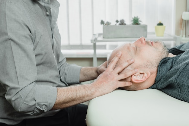 Foto ostheopatische behandlung eines patienten mit cst sanfter hands-on-technik