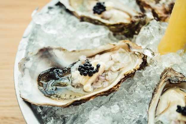 Ostra fresca e fresca com caviar em cima e limão