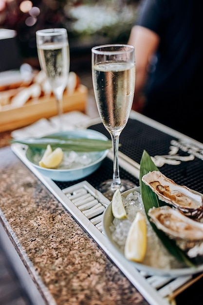 Ostras abertas frescas com um copo de vinho prosecco gelado servido na mesa Delícias de frutos do mar