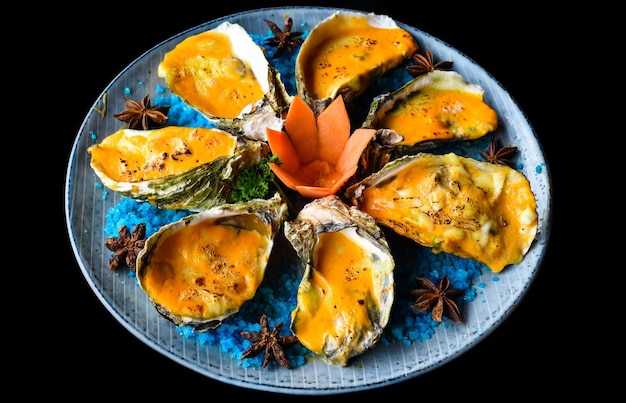 ostras horneadas con queso en un plato con sal azul aisladas en la vista lateral negra