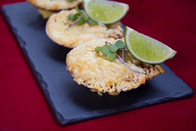 ostras rellenas con queso y gajos de lima