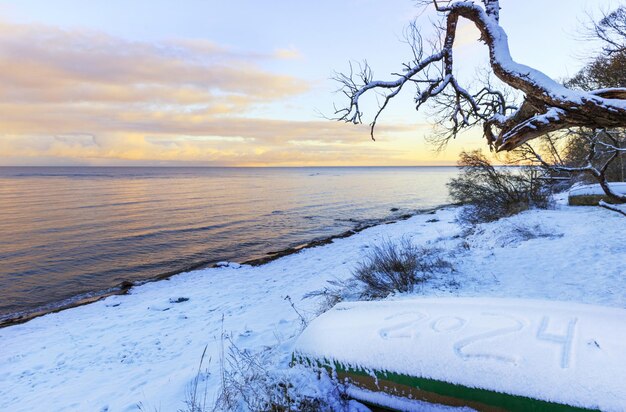 Ostseeküste im Winter Fischerschiff mit einer Inschrift auf dem Schnee frohes neues Jahr