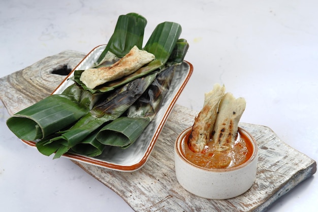 Otak Otak,gegrillte Fischfrikadellen umwickelt mit Bananenblättern, serviert mit scharfer Soße