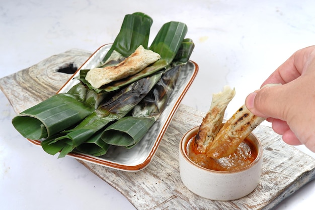 otak otak, pasteles de pescado a la parrilla envueltos en hoja de plátano, servidos con salsa picante