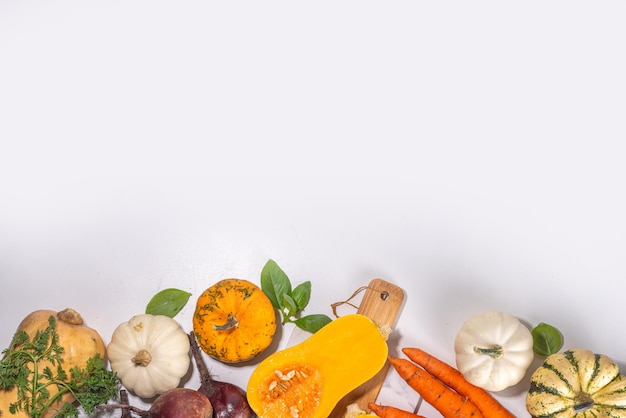 Otoño cocinando fondo de alimentos orgánicos de granja concepto de cosecha tabla de cortar con verduras frescas calabazas coloridas calabaza remolacha zanahorias repollo en una mesa de mármol blanco fondo de cocina