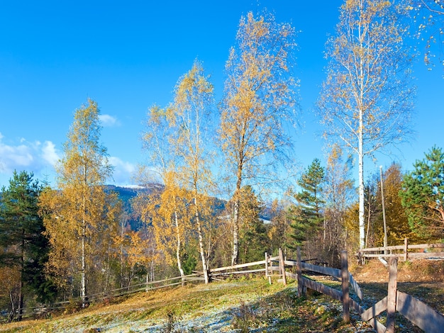 Otoño de escarcha en las afueras de la aldea de montaña glade