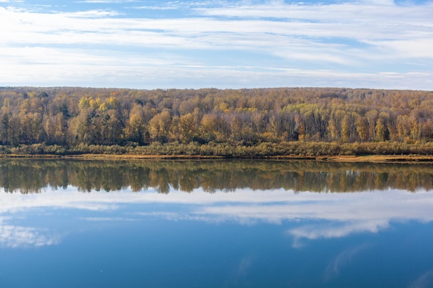 Otoño hermoso y ancho río entre los bosques. Lugar tranquilo y silencioso con colores otoñales. En medio de la isla fluvial. Vista desde arriba a la distancia