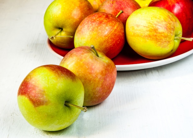 Otoño manzanas en una mesa de madera blanca