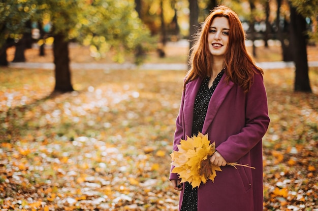 Otoño moda tonos tierra estilo brillante paleta de colores de otoño retrato de niña pelirroja en abrigo púrpura