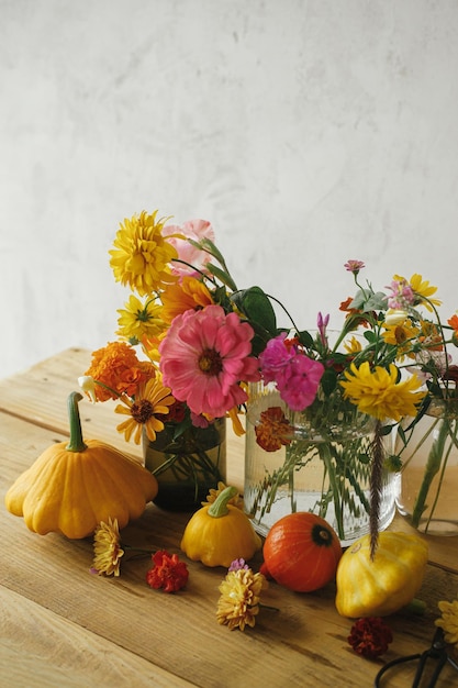 Foto otoño moody bodegón coloridas flores calabazas calabazas composición sobre mesa de madera rústica