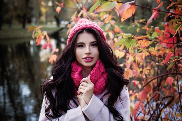 Otoño mujer morena en hojas de arce rojo al aire libre Hermosa chica en el parque de otoño