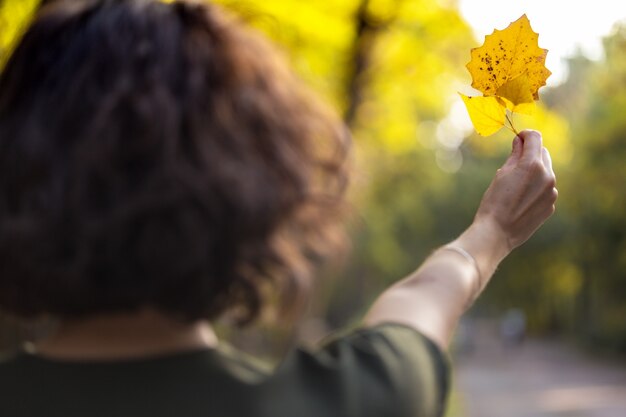 Otoño - niña sostiene una hoja amarilla