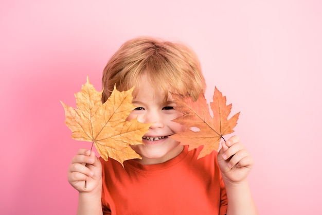 Otoño niño se esconde detrás de la hoja de arce feliz infancia otoño tiempo niño sostiene la hoja de arce