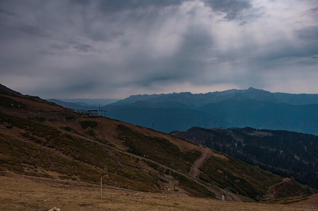 Otoño en el norte del Cáucaso, estación de esquí Rosa Khutor en temporada baja. Rusia, Sochi. Tonificación vintage. Antecedentes de viaje. Cielo dramático, puesta del sol, hermosas nubes pesadas.