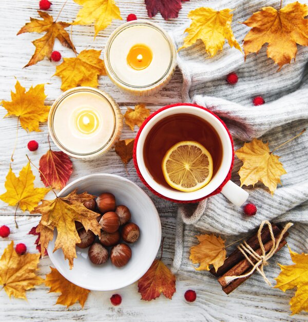 Otoño plano con taza de té y hojas.