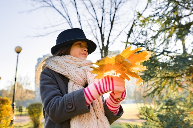 Otoño retrato al aire libre de niña con hojas de arce amarillas