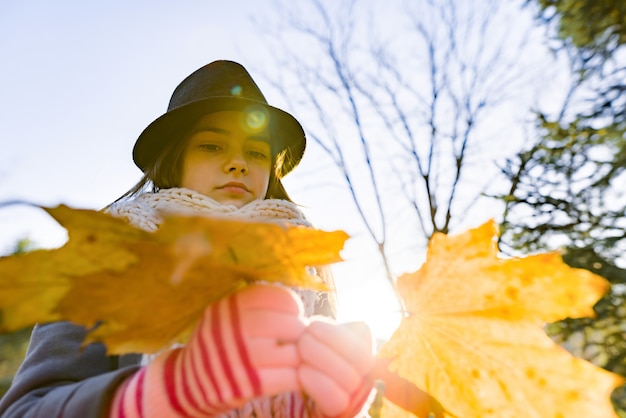 Otoño retrato al aire libre de niña con hojas de arce amarillas