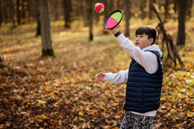 Otoño retrato al aire libre de niño jugar con atrapar y lanzar juego de pelota