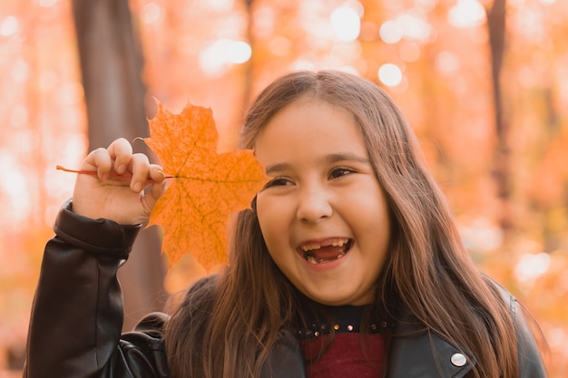 Otoño retrato emocional de niño riendo caminando en el parque o bosque