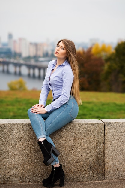 Otoño retrato de primer plano de la hermosa modelo con el pelo largo, vistiendo jeans y camisa azul