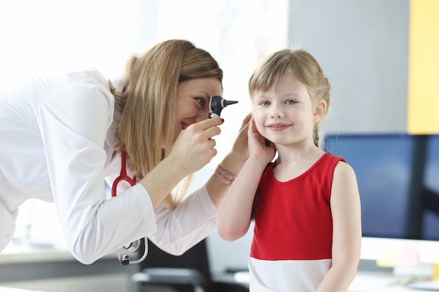 Otorrinolaringólogo examina la oreja de la niña