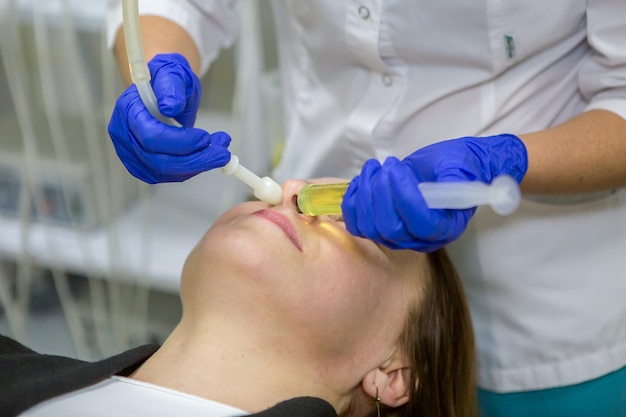 Foto el otorrinolaringólogo lava la nariz del paciente el otorrinolaringólogo inyecta líquido en los senos nasales