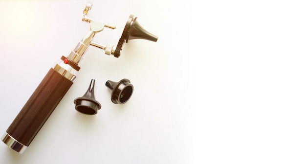 Otoscopio para control de oído para médico ENT con tres tamaños de piezas de espéculos sobre fondo borroso con enfoque selectivo de espacio de copia