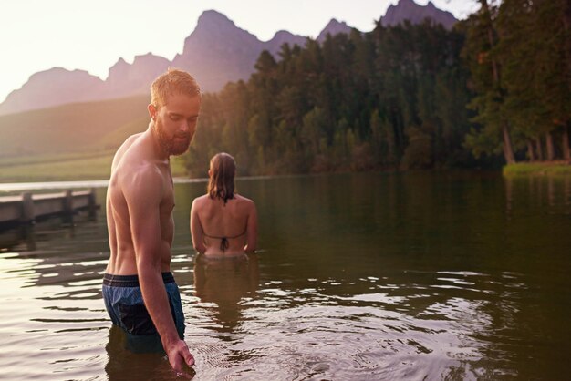 Otro día perfecto de verano Foto de una joven pareja cariñosa disfrutando de un baño en un lago