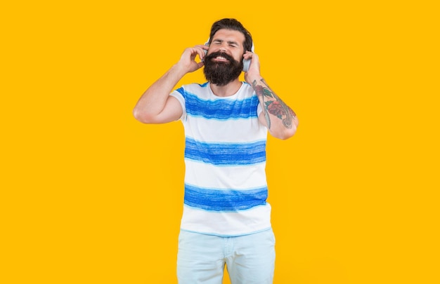 Ouça música dispositivo moderno de homem feliz hipster homem ouça música em fones de ouvido