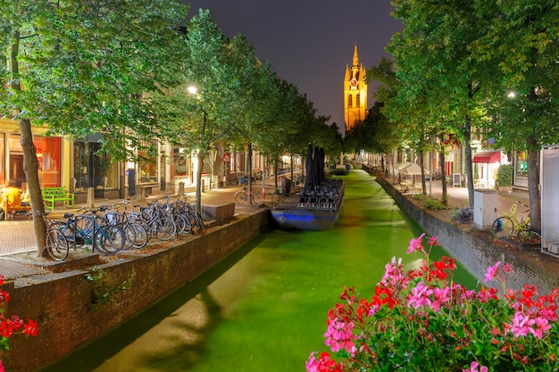 Oude Delft canal y torre inclinada de gótico protestante iglesia Oude Kerk en la noche, Delft, Holanda, Países Bajos