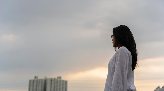 Oung Frau mit Blick auf die Stadt Schöne Stadt Hintergrund in sanftem Licht Zukünftiger Freiheit Geschäftserfolg