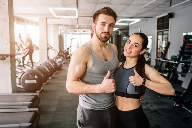 ouple de pie en la sala de entrenamiento del club deportivo juntos