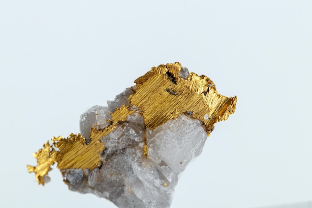 Ouro de metal de pedra mineral macro em quartzo em um fundo branco