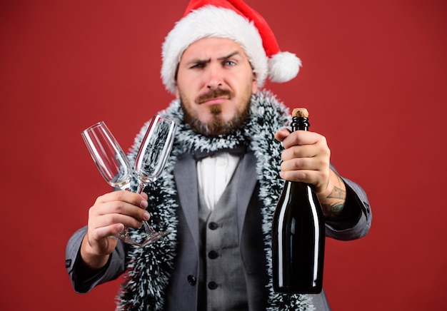 Ouropel de chapéu de papai noel chefe comemorar ano novo ou natal convite para festa de natal junte-se à celebração de natal homem barbudo hipster santa segurar garrafa festa de natal corporativa vamos beber champanhe