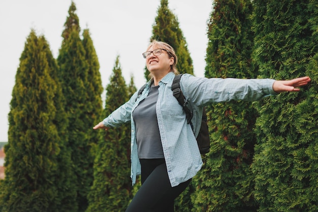 Outddor-Porträt einer glücklichen europäischen Rentnerin mit Rucksack, die die schöne Natur beim Nordic Walking genießt Alternde Menschen aktiver Lebensstil und Gesundheitskonzept