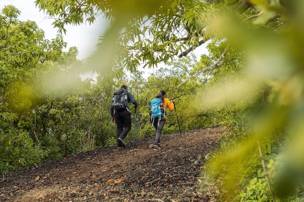 Outdoor-Abenteuer Mann mit schwarzem Rucksack und Frau mit blauem Rucksack Erforschen des Berges