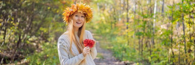 Outdoor-Lebensstil Nahaufnahme Porträt einer charmanten blonden jungen Frau, die einen Herbstkranz trägt