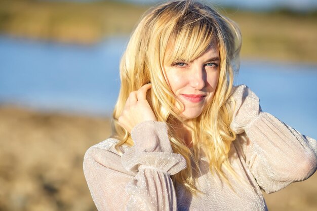 Outdoor-Nahaufnahme Porträt schönes blondes Mädchen mit Jugend- und Hautpflege attraktiver Blick in die Kamera Lichttaste