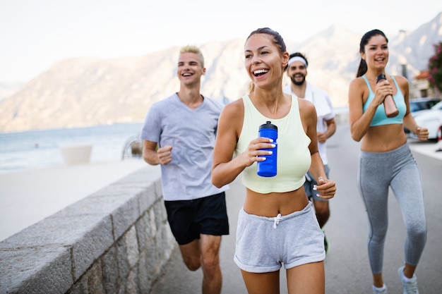 Outdoor-Porträt einer Gruppe von Freunden, die am Meer laufen und joggen