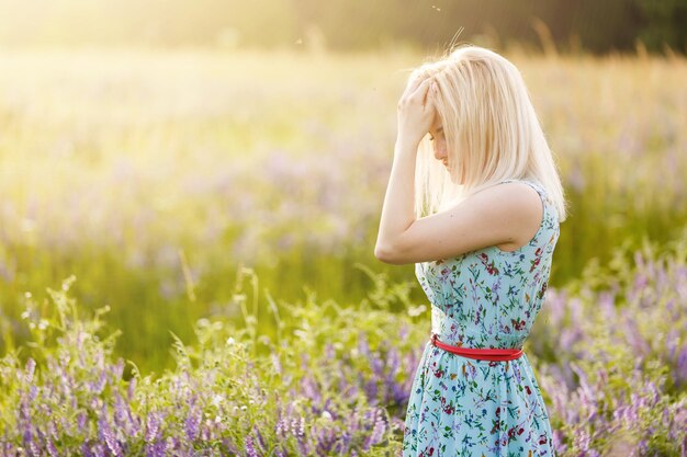 Outdoor-Porträt einer schönen blonden Frau mittleren Alters. attraktives sexy Mädchen in einem Feld mit Blumen